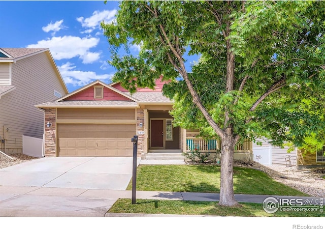 2244 Woodbury Ln, Fort Collins, CO 80524 - view of front of house featuring an attached garage, driveway, a front lawn, stone siding, and covered porch