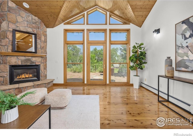 4223 Eldorado Springs Dr, Boulder, CO 80303 - living room with baseboard heating, vaulted ceiling, wood-type flooring, a stone fireplace, and wooden ceiling