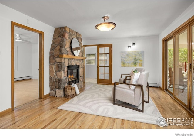 4223 Eldorado Springs Dr, Boulder, CO 80303 - living area with a baseboard heating unit, wood finished floors, and a fireplace