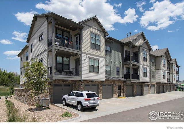 285 High Point Dr Unit H-104, Longmont, CO 80504 - view of building exterior featuring an attached garage and driveway