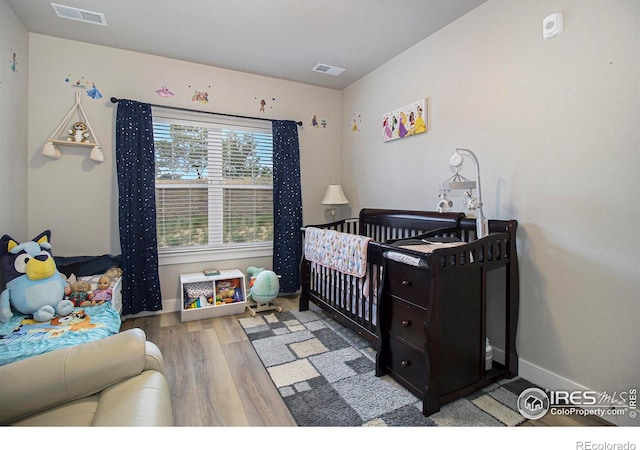 285 High Point Dr Unit H-104, Longmont, CO 80504 - bedroom featuring wood finished floors and a crib