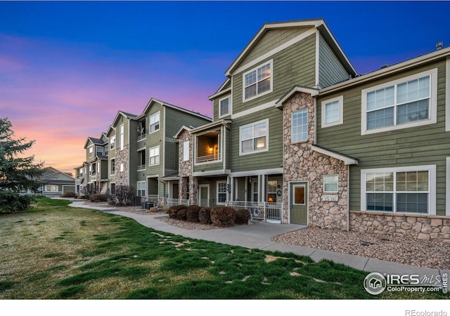6925 19th St Unit 15, Greeley, CO 80634 - view of front of property featuring stone siding, a yard, and a residential view