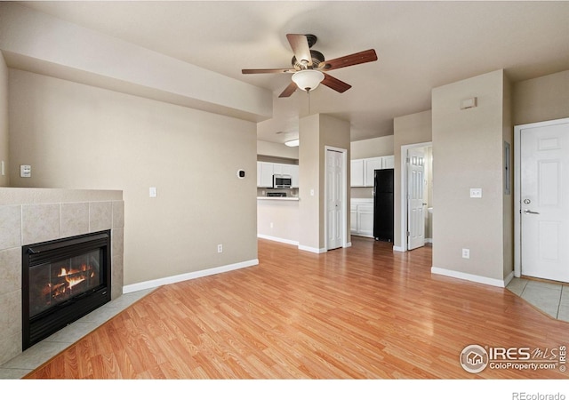 6925 19th St Unit 15, Greeley, CO 80634 - unfurnished living room with a ceiling fan, light wood-style flooring, and a fireplace