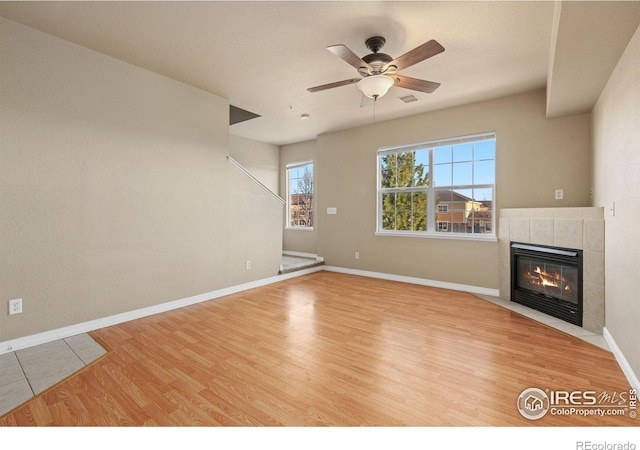 6925 19th St Unit 15, Greeley, CO 80634 - unfurnished living room featuring wood finished floors, a tile fireplace, and ceiling fan