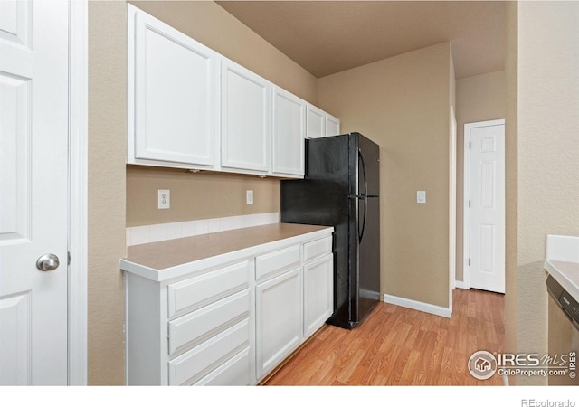 6925 19th St Unit 15, Greeley, CO 80634 - kitchen featuring freestanding refrigerator, light wood-type flooring, white cabinets, and light countertops