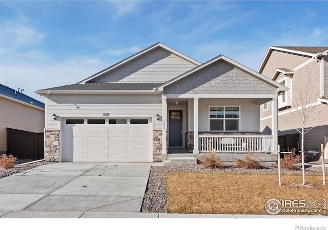 9873 Ceylon St, Commerce City, CO 80022 - craftsman house with a porch, concrete driveway, an attached garage, and stone siding