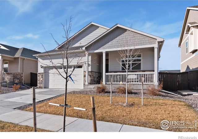 9873 Ceylon St, Commerce City, CO 80022 - view of front of property featuring a porch, an attached garage, stone siding, and driveway