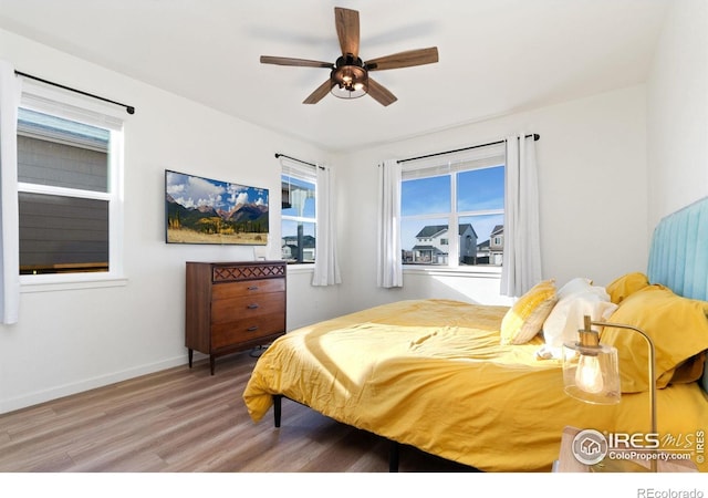 9873 Ceylon St, Commerce City, CO 80022 - bedroom with wood finished floors, multiple windows, and ceiling fan