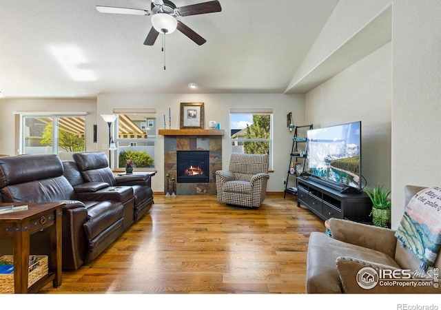 1613 Alpine Ave, Berthoud, CO 80513 - living area featuring ceiling fan, a tiled fireplace, wood finished floors, and vaulted ceiling