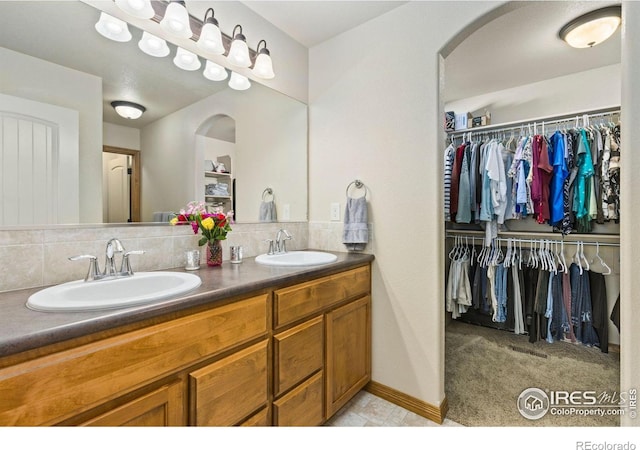 1613 Alpine Ave, Berthoud, CO 80513 - full bathroom featuring double vanity, backsplash, and a spacious closet