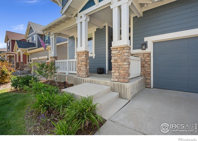 5127 Exploration Ln, Fort Collins, CO 80528 - view of exterior entry featuring a porch, stone siding, a garage, and concrete driveway