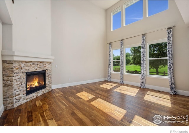 5127 Exploration Ln, Fort Collins, CO 80528 - unfurnished living room with a high ceiling, wood finished floors, and a fireplace