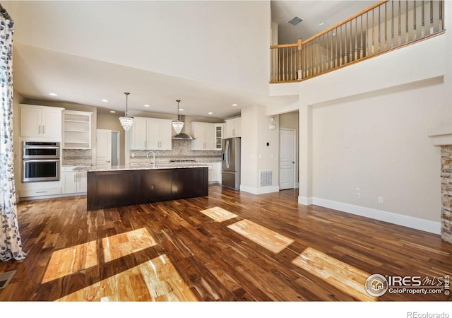 5127 Exploration Ln, Fort Collins, CO 80528 - kitchen with appliances with stainless steel finishes, wall chimney range hood, dark wood-type flooring, tasteful backsplash, and white cabinets