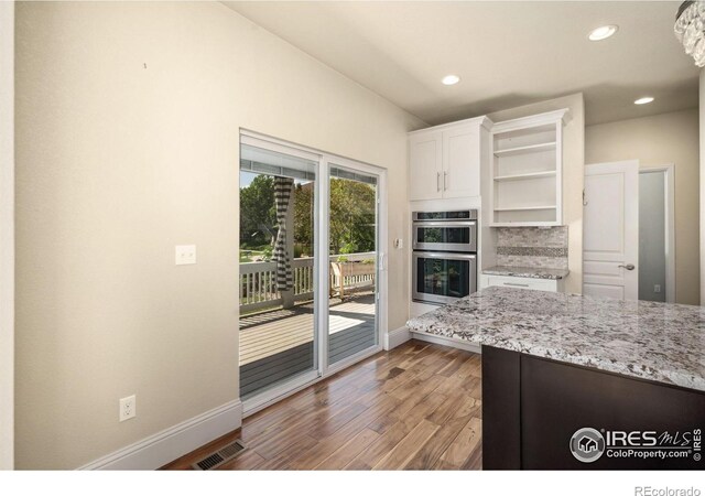 5127 Exploration Ln, Fort Collins, CO 80528 - kitchen featuring open shelves, stainless steel double oven, white cabinets, light wood-style floors, and recessed lighting