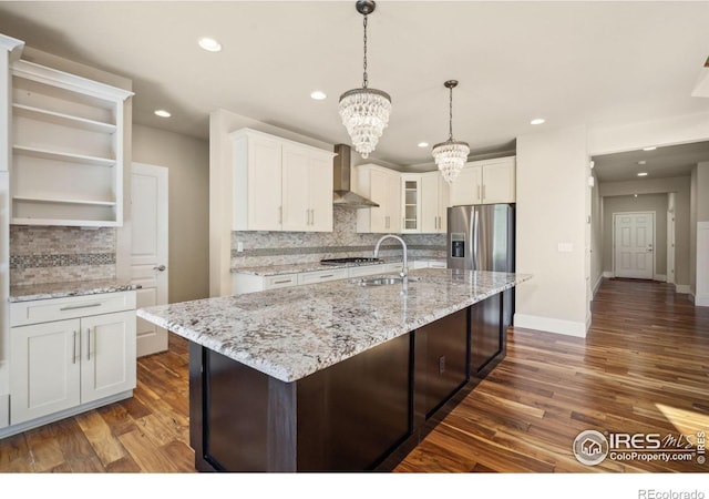 5127 Exploration Ln, Fort Collins, CO 80528 - kitchen with wall chimney exhaust hood, a chandelier, decorative backsplash, appliances with stainless steel finishes, and white cabinets