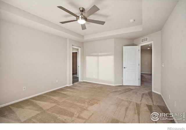5127 Exploration Ln, Fort Collins, CO 80528 - unfurnished bedroom featuring carpet, a tray ceiling, and ceiling fan