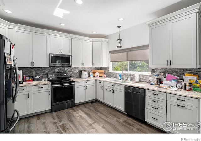 1201 102nd Ave, Greeley, CO 80634 - kitchen featuring black appliances, tasteful backsplash, wood finished floors, and recessed lighting