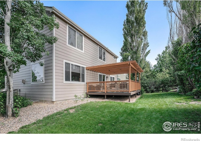 1201 102nd Ave, Greeley, CO 80634 - rear view of property featuring a wooden deck, a pergola, and a lawn