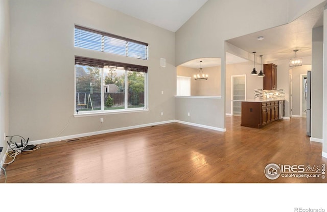 1937 Mahogany Way, Severance, CO 80550 - unfurnished living room featuring a chandelier, dark wood-style floors, and high vaulted ceiling