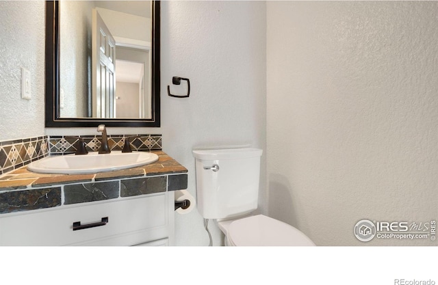 1937 Mahogany Way, Severance, CO 80550 - half bath with a textured wall, vanity, and backsplash