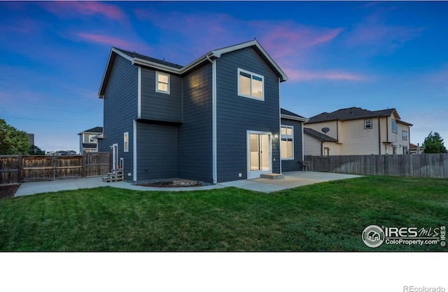 1937 Mahogany Way, Severance, CO 80550 - back of house at dusk with a patio area and a fenced backyard