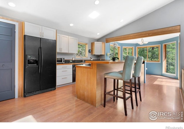 3727 Gamble Gulch Rd, Black Hawk, CO 80422 - kitchen with black appliances, light wood-style floors, vaulted ceiling, a breakfast bar, and recessed lighting