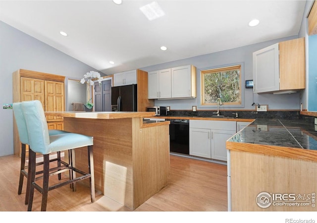 3727 Gamble Gulch Rd, Black Hawk, CO 80422 - kitchen featuring black appliances, a breakfast bar, light wood-type flooring, lofted ceiling, and a center island
