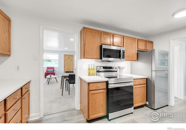 4240 Harlan St, Wheat Ridge, CO 80033 - kitchen featuring appliances with stainless steel finishes, light countertops, and tasteful backsplash