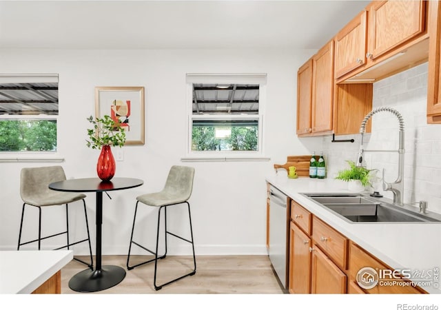 4240 Harlan St, Wheat Ridge, CO 80033 - kitchen featuring plenty of natural light, light wood-style flooring, tasteful backsplash, and light countertops