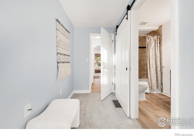 4240 Harlan St, Wheat Ridge, CO 80033 - hallway featuring a barn door and wood finished floors