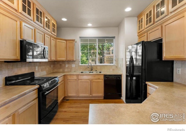 3632 Cassiopeia Ln, Fort Collins, CO 80528 - kitchen with black appliances, light brown cabinetry, light wood-style flooring, light countertops, and backsplash