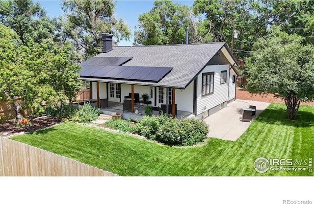 5326 Lowell Blvd, Denver, CO 80221 - rear view of house with solar panels, a patio, a chimney, and roof with shingles