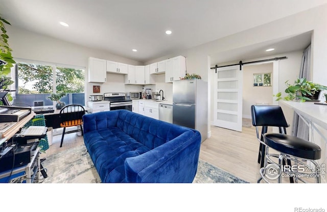 5326 Lowell Blvd, Denver, CO 80221 - living area with a barn door, recessed lighting, and light wood-style floors