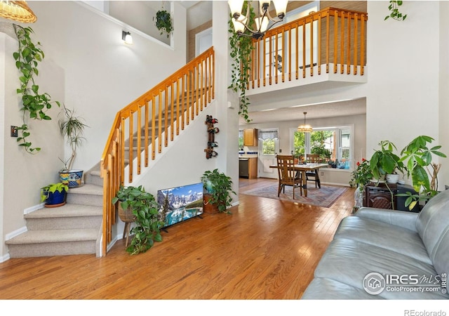 1026 Red Oak Dr, Longmont, CO 80504 - living room with a chandelier, wood finished floors, stairway, and a towering ceiling