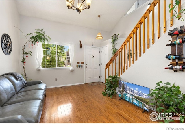 1026 Red Oak Dr, Longmont, CO 80504 - foyer featuring wood finished floors, a chandelier, stairs, and lofted ceiling