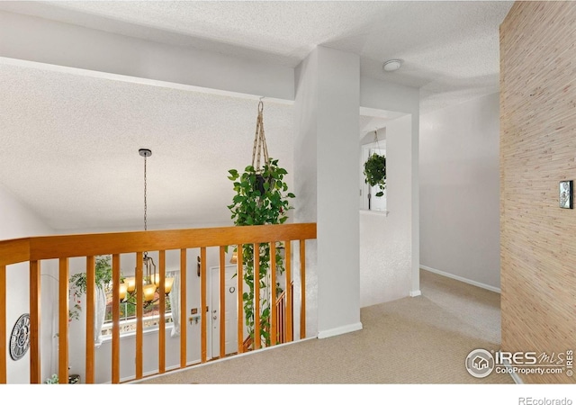 1026 Red Oak Dr, Longmont, CO 80504 - hall featuring carpet flooring, a textured ceiling, and a chandelier