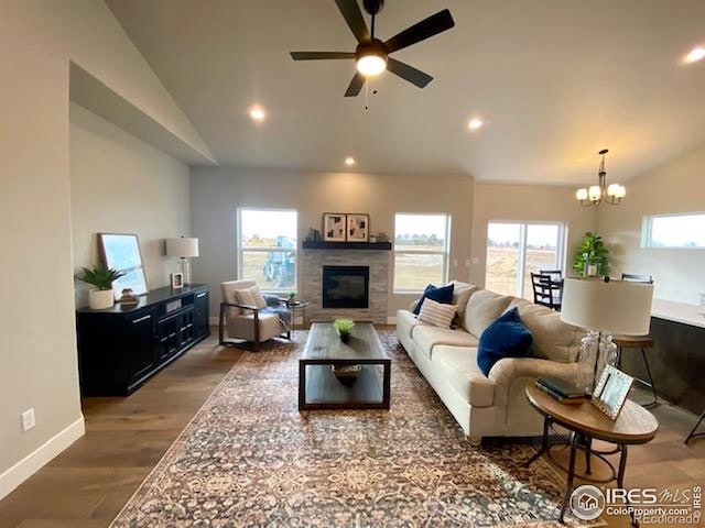 7156 Feather Reed Dr, Wellington, CO 80549 - living area featuring vaulted ceiling, wood finished floors, recessed lighting, a glass covered fireplace, and ceiling fan