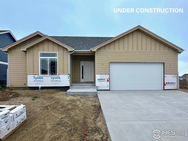 7156 Feather Reed Dr, Wellington, CO 80549 - view of front of home featuring an attached garage, concrete driveway, board and batten siding, and roof with shingles