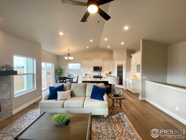 7156 Feather Reed Dr, Wellington, CO 80549 - living room with a chandelier, wood finished floors, ceiling fan, recessed lighting, and lofted ceiling