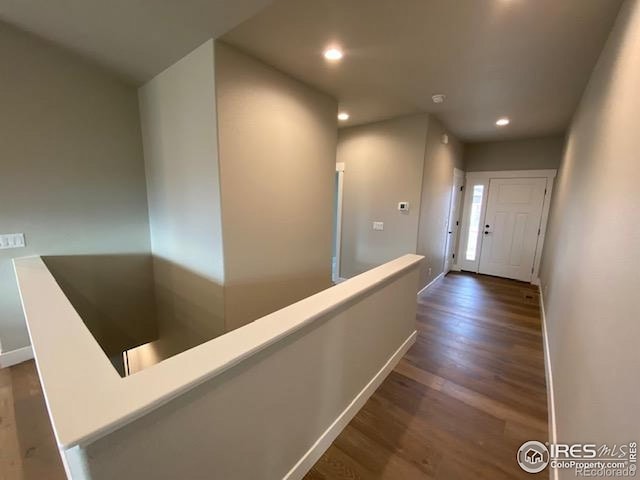 7156 Feather Reed Dr, Wellington, CO 80549 - hallway with wood finished floors, an upstairs landing, and recessed lighting