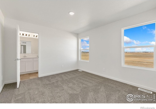 3178 Buffalo Grass Ln, Wellington, CO 80549 - unfurnished bedroom featuring carpet floors, multiple windows, connected bathroom, and recessed lighting