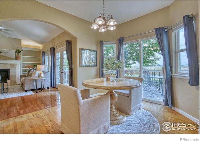 2408 Eagleview Cir, Longmont, CO 80504 - dining space featuring a ceiling fan, arched walkways, plenty of natural light, light wood-style floors, and vaulted ceiling