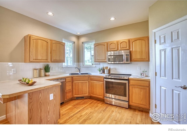 2408 Eagleview Cir, Longmont, CO 80504 - kitchen featuring appliances with stainless steel finishes, a peninsula, backsplash, light countertops, and recessed lighting