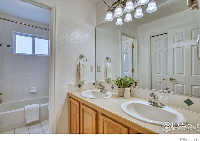 2408 Eagleview Cir, Longmont, CO 80504 - full bath featuring double vanity, washtub / shower combination, a chandelier, tile patterned floors, and a textured wall