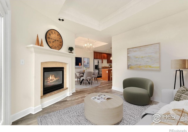 1827 N Grant St Unit 604, Denver, CO 80203 - living area featuring wood finished floors, a chandelier, a raised ceiling, a glass covered fireplace, and crown molding
