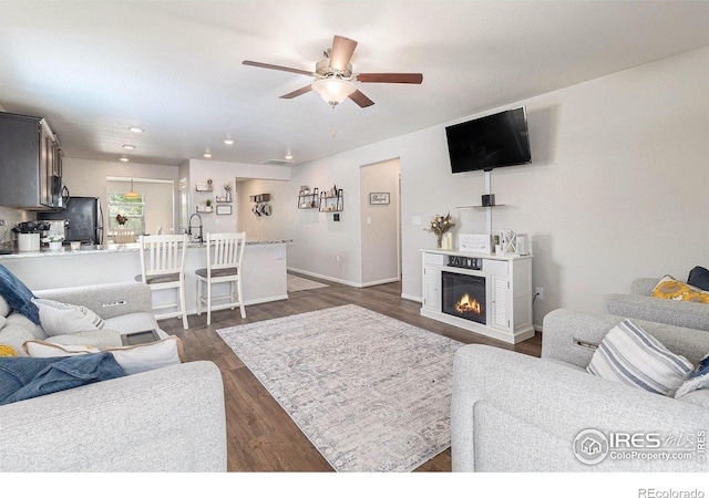 2065 Wildwood St, Lochbuie, CO 80603 - living room with a ceiling fan, dark wood-style flooring, a glass covered fireplace, and recessed lighting