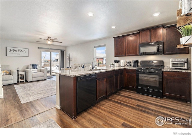 2065 Wildwood St, Lochbuie, CO 80603 - kitchen with black appliances, a peninsula, dark brown cabinetry, dark wood-style floors, and open floor plan