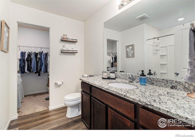 2065 Wildwood St, Lochbuie, CO 80603 - bathroom with wood finished floors, a walk in closet, vanity, and a shower