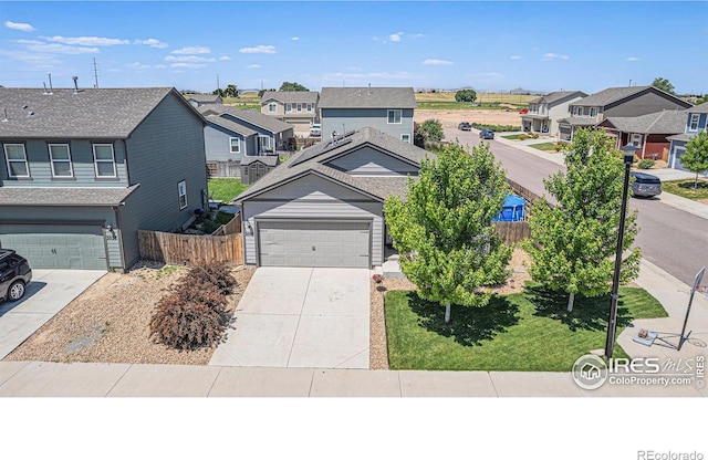 2065 Wildwood St, Lochbuie, CO 80603 - view of front of property with a residential view, concrete driveway, and a garage