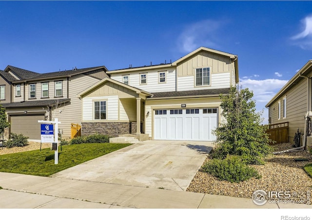 6645 Dry Fork Dr, Frederick, CO 80516 - view of front of house with board and batten siding, a garage, concrete driveway, and stone siding